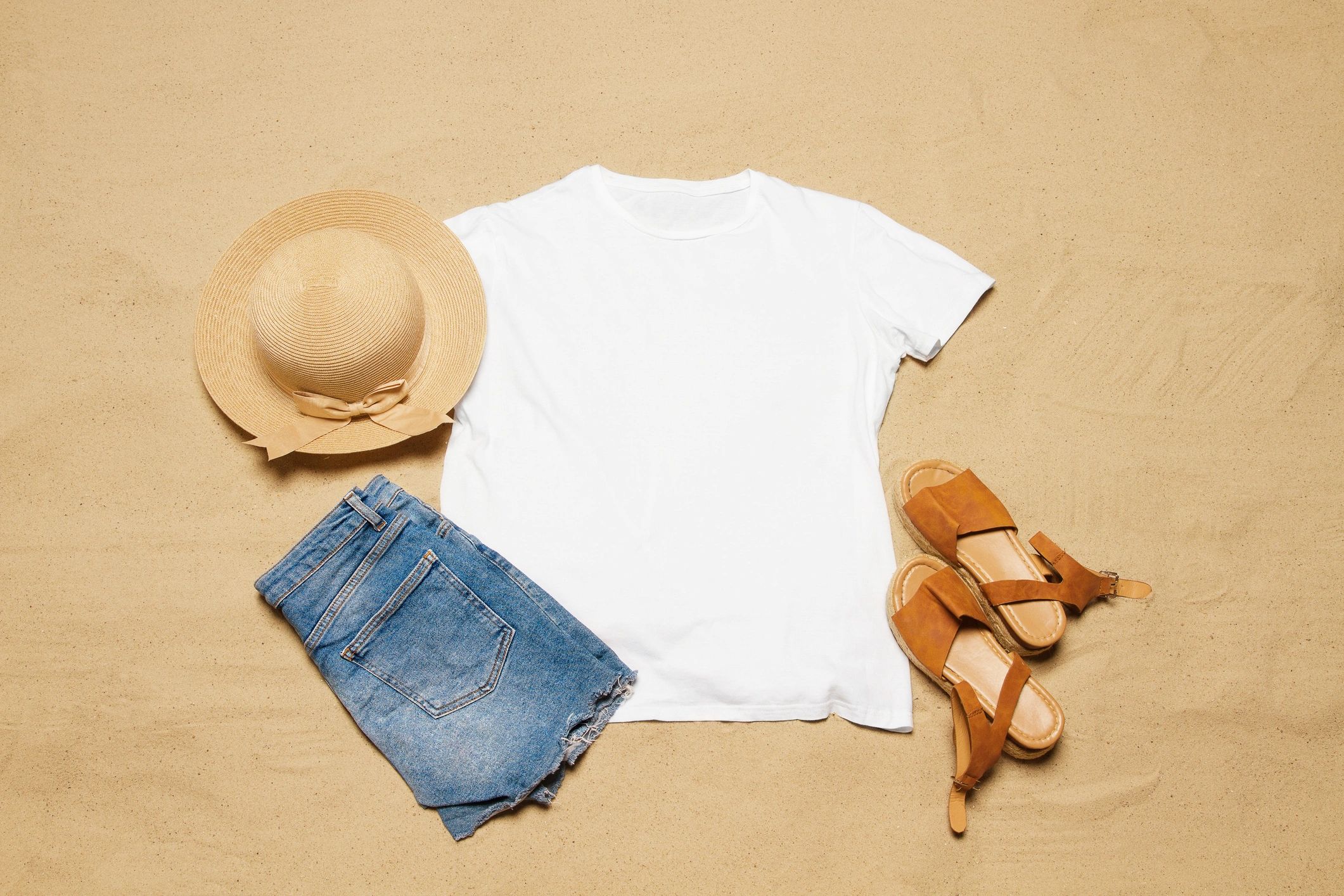 White t-shirt mockup on beach-themed flat lay with accessories.