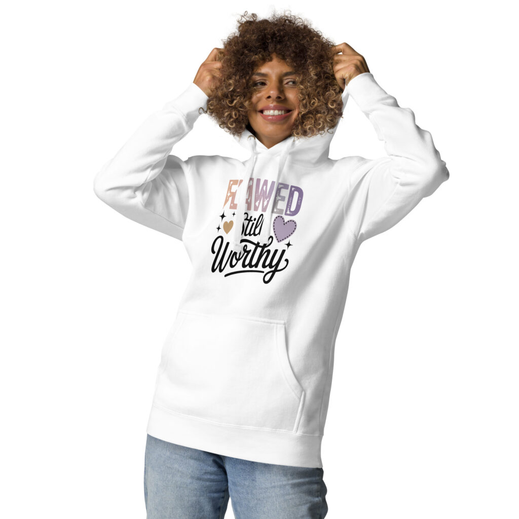 Smiling woman wearing a white hoodie with the phrase "Flawed Still Worthy".